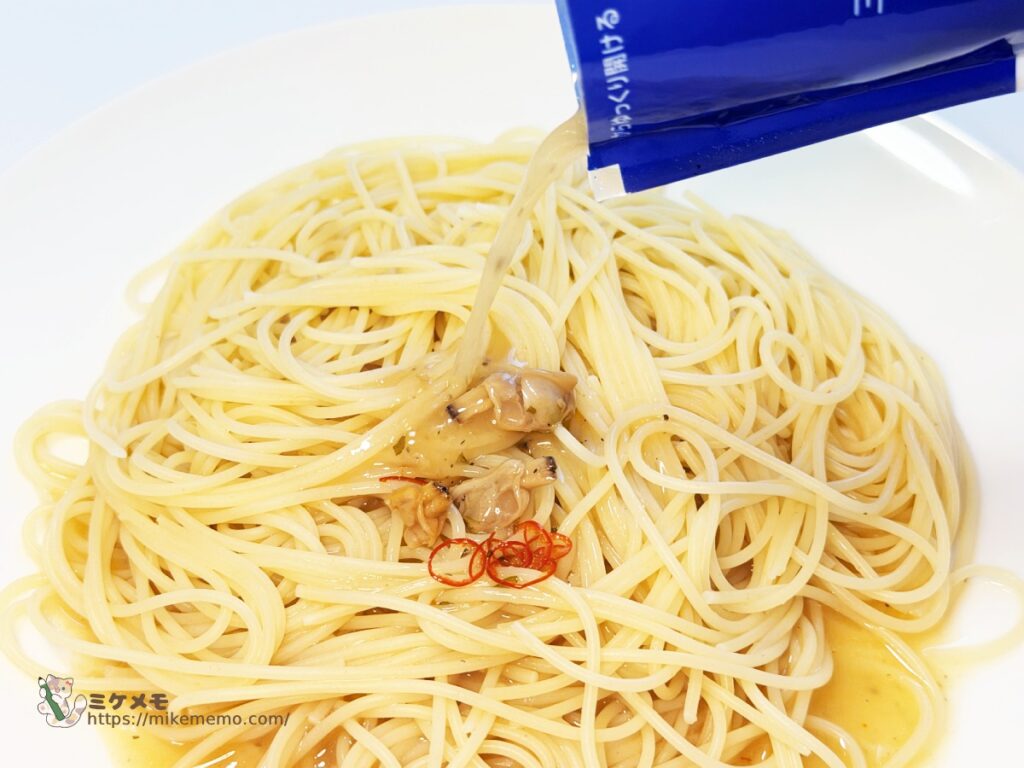 ゆでたパスタに青の洞窟 ボンゴレビアンコのソースをかけているところ